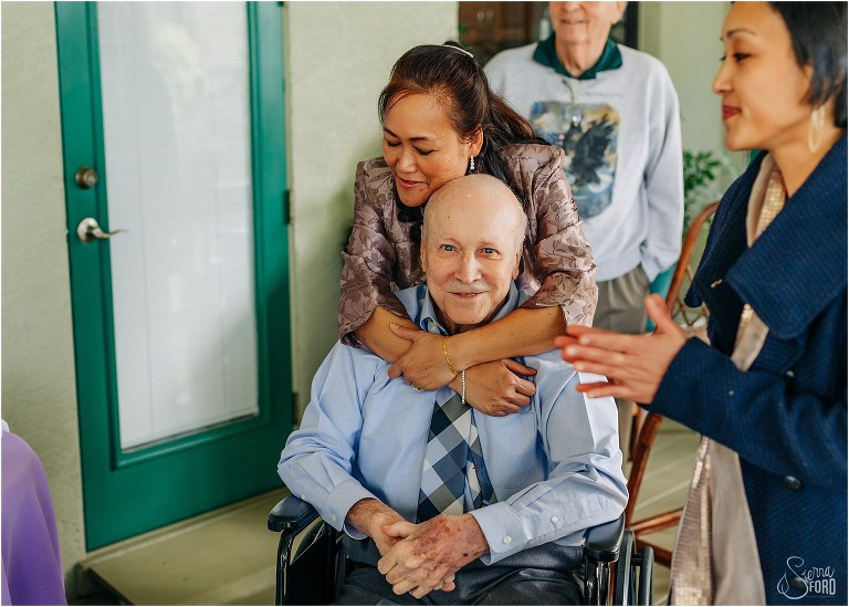 mother of the bride hugs grandfather as everyone prepares for Florida elopement