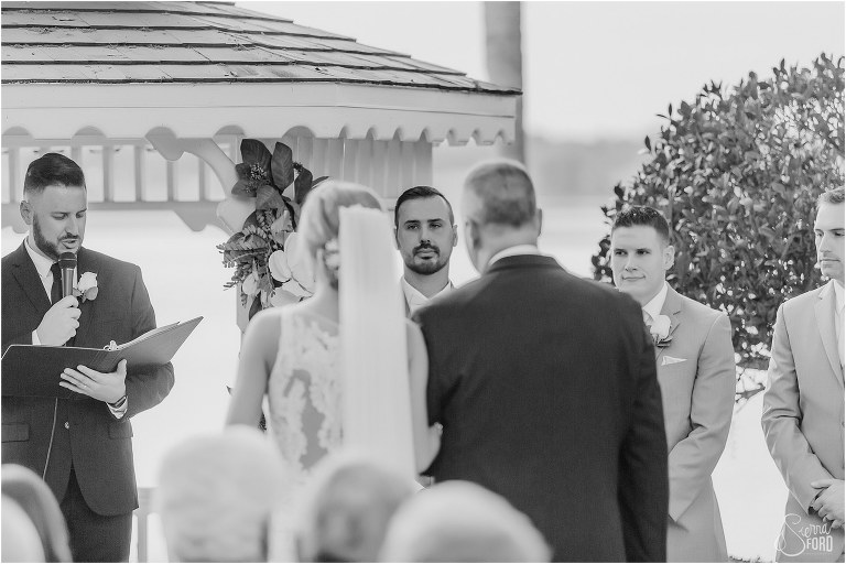 groom's face peaks through as bride & her father walk down the aisle at Town Manor wedding ceremony