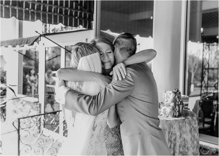mother of the bride pulls bride & groom into big hug after Town Manor wedding ceremony