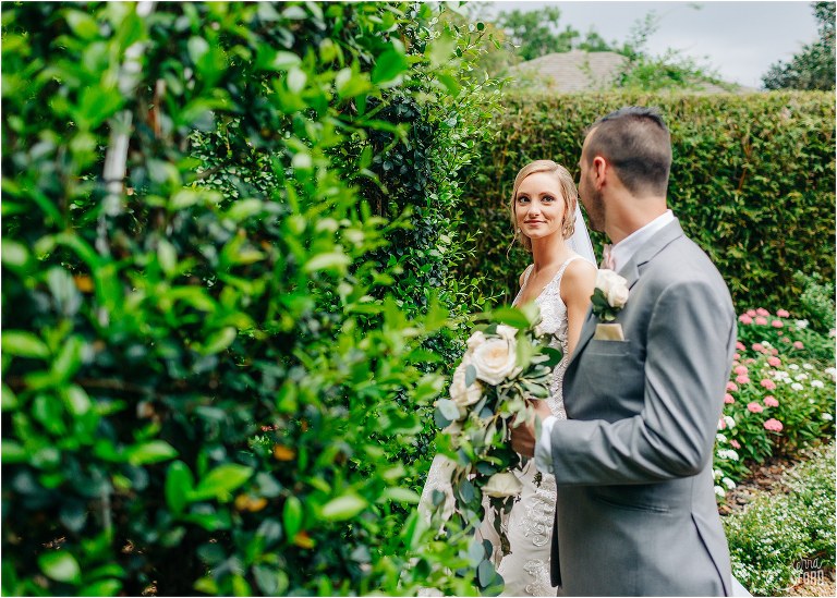 bride looks lovingly at her groom as he leads her through the gardens at Town Manor wedding