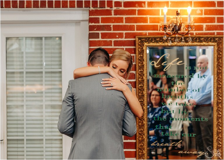 loved ones look on in mirror as bride & groom share first dance at Town Manor wedding reception