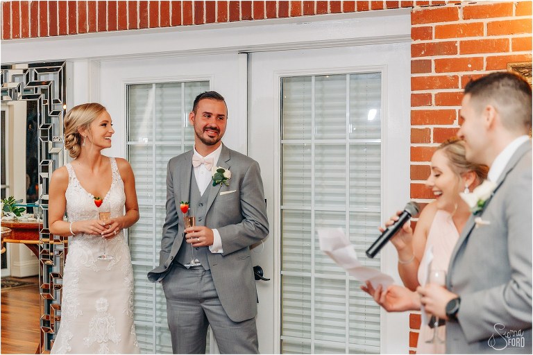 bride & groom laugh as maid of honor gives her emotional speech at Town Manor wedding reception