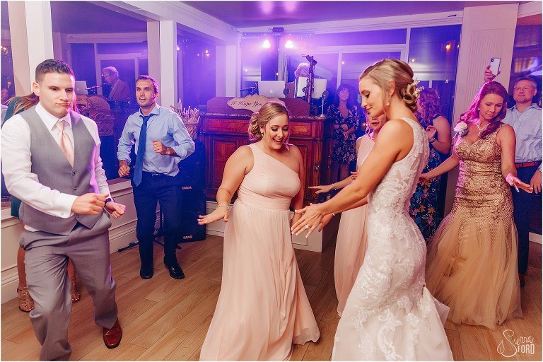 bride busts a move on the dance floor with maid of honor at Town Manor wedding reception
