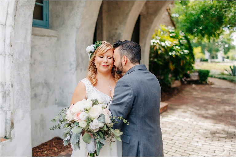 groom nuzzles into bride's neck under Casa Feliz archway at Winter Park wedding