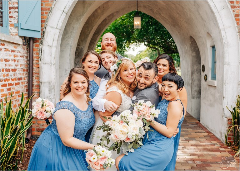 wedding party give bride and groom surprise group hug at Winter Park wedding