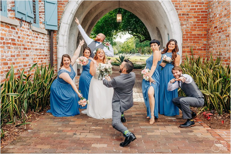 wedding party strikes a pose in Casa Feliz archway at Winter Park wedding