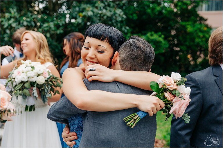 maid of honor gives groom huge hug after Winter Park wedding ceremony