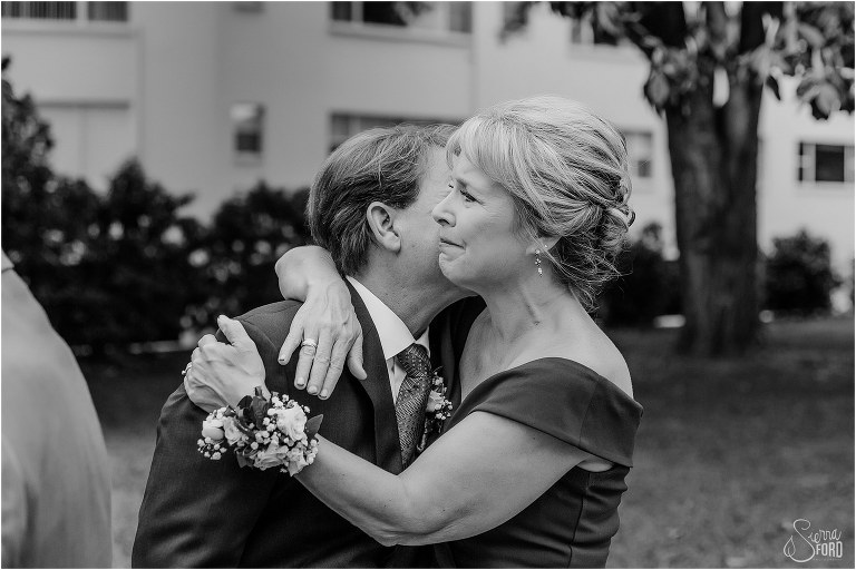 parents of the bride share an emotional hug after Winter Park wedding ceremony