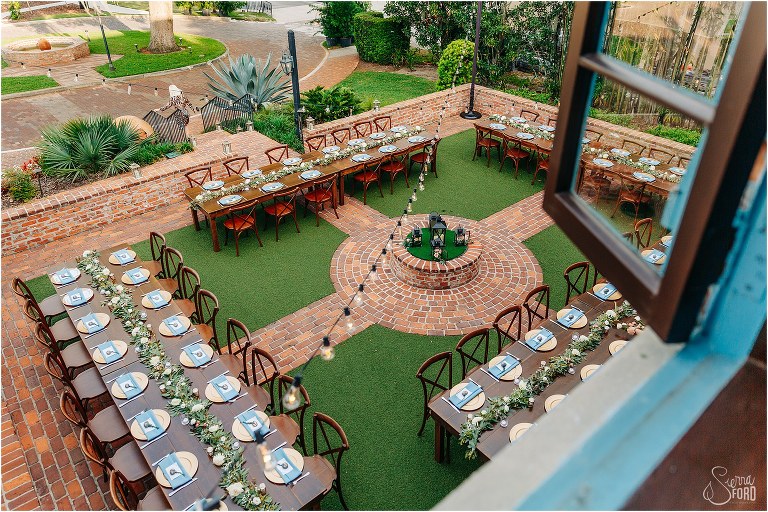 overhead shot of farmhouse tables set up for Winter Park wedding reception under the market lights