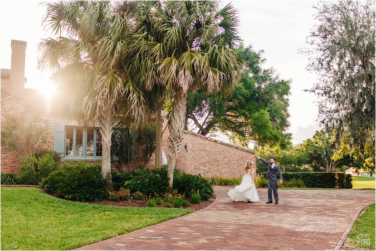 groom twirls his bride as sun sets behind Casa Feliz at Winter Park wedding