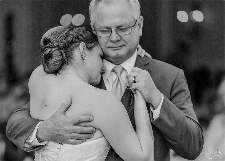 father of the bride holds daughter tight during father/daughter dance at River House wedding reception