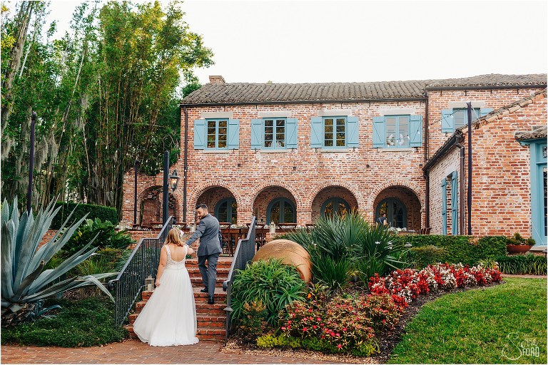 groom leads bride up Casa Feliz steps at Winter Park wedding