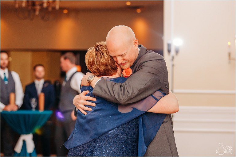 grooms hugs his mother tight during their mother/son dance at River House wedding reception