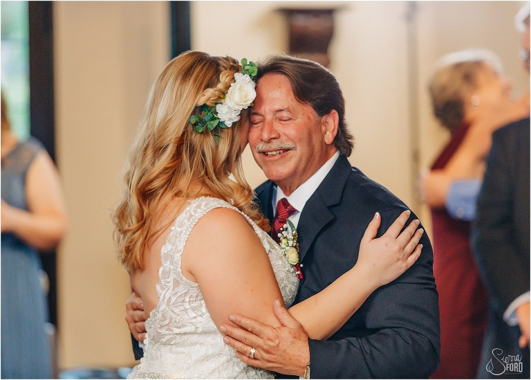 father of the bride smiles as he dances with his daughter during Winter Park wedding reception