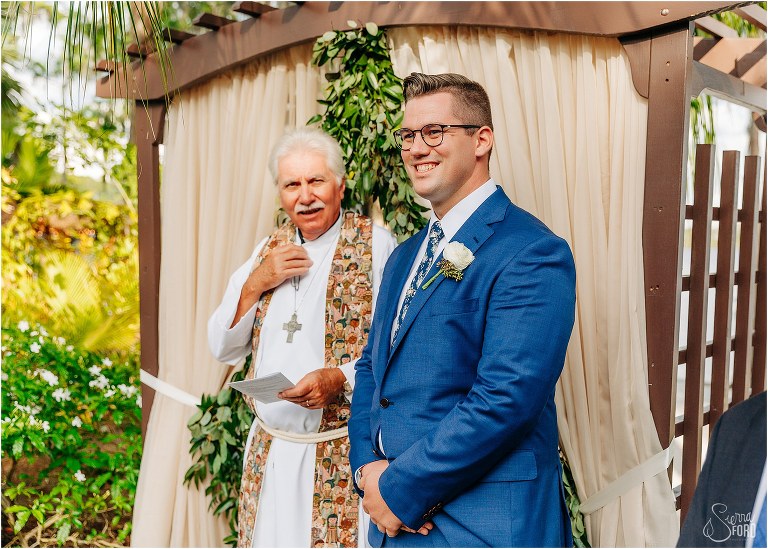 groom smiles at alter as Disney themed garden wedding ceremony begins