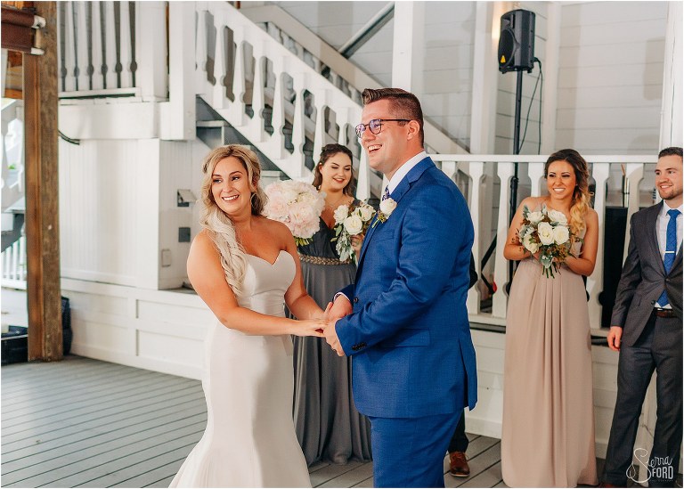 bride & groom laugh while their guests cheer them on as they begin their first dance Disney themed garden wedding reception