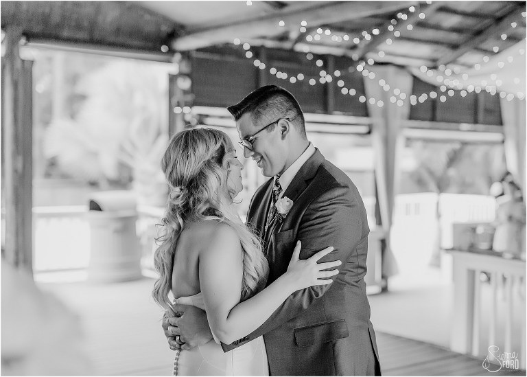 groom smiles down at bride during first dance at Disney themed garden wedding reception