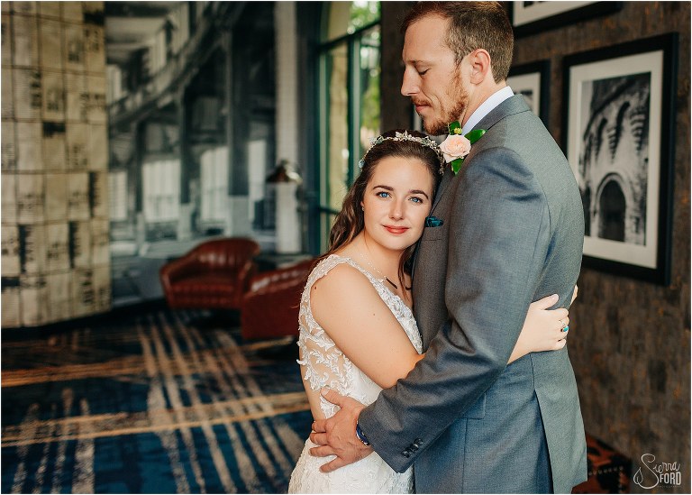 bride's blue eyes pierce lens as groom hugs her before Savannah elopement