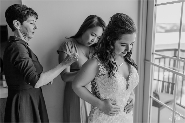 mom and friend help bride into dress before Savannah elopement