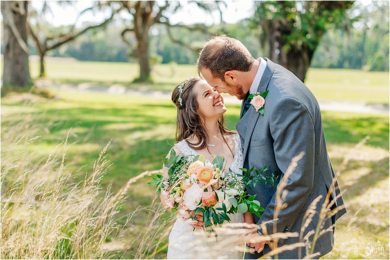 bride & groom giggle as they cuddle up at Wormsloe Plantation after Savannah elopement