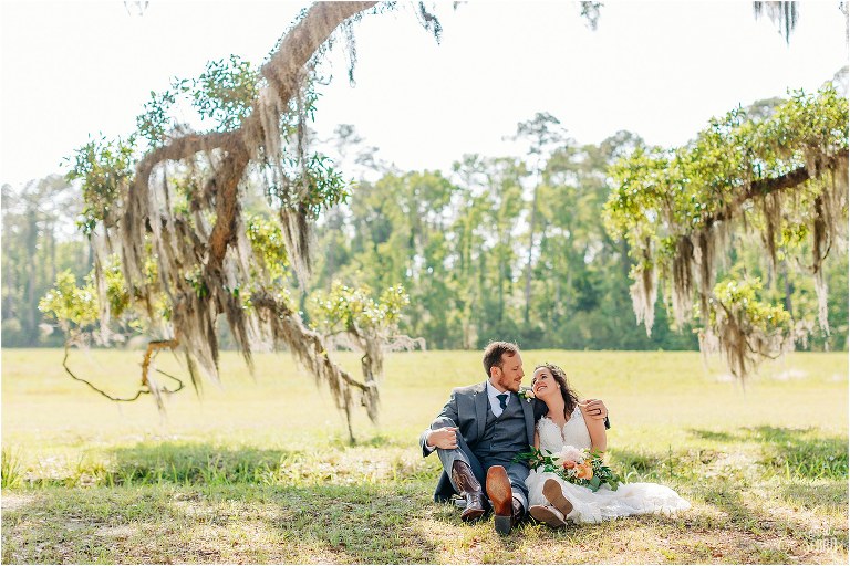 bride & groom snuggle up on the ground at Wormsloe Plantation after Savannah elopement