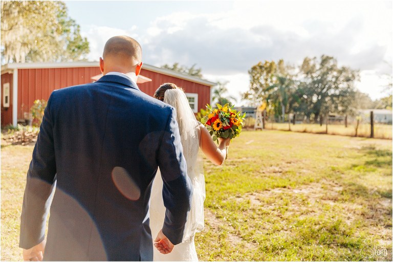 sun glares over newly married couple after DIY Florida Barn Wedding