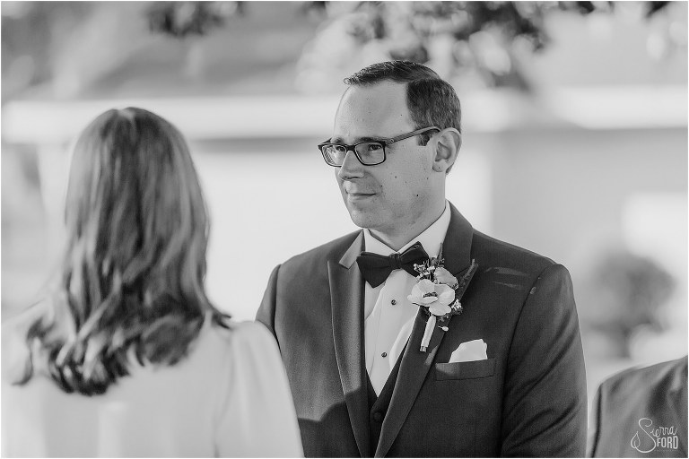 groom looks lovingly at bride during elegant backyard elopement ceremony