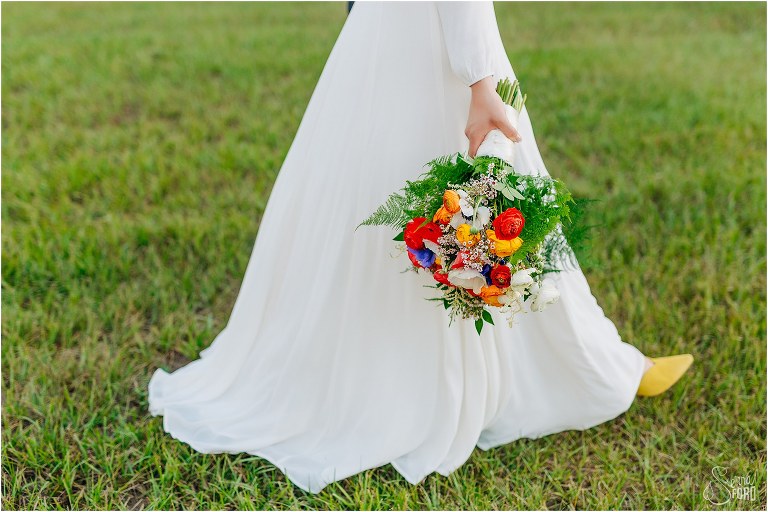 bride walks with gorgeous bright bridal bouquet by Eva's Creations at elegant backyard elopement