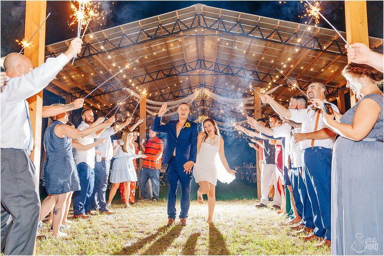 bride & groom skip out of sparkler grand exit at DIY Florida Barn Wedding reception