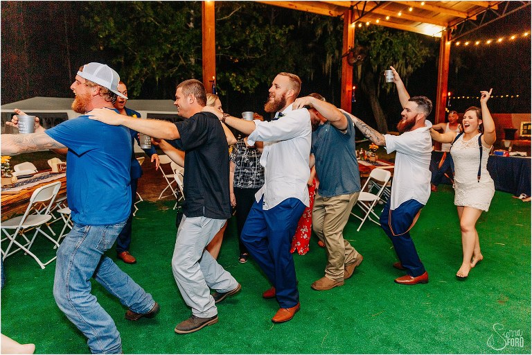 bride & guests start conga line at DIY Florida Barn Wedding reception