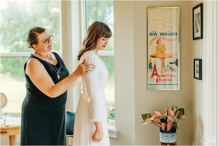 mother of the bride helps bride get ready before elegant backyard elopement
