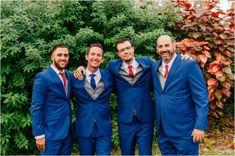 groom hangs out with groomsmen before waterfront wedding