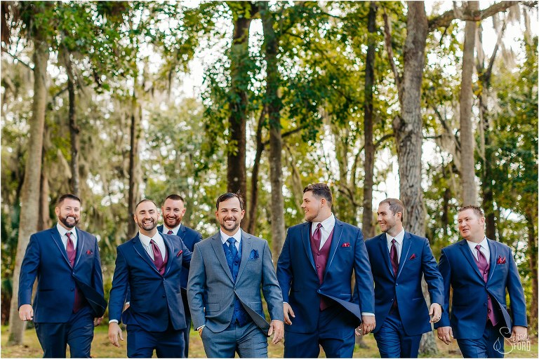 groom and groomsmen laugh as they take a stroll before Horsepower Ranch wedding