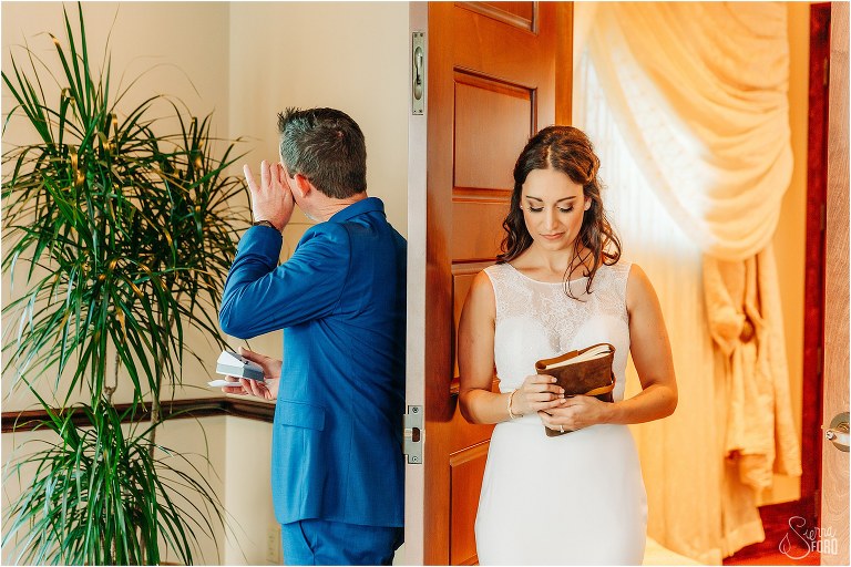 bride & groom exchange emotional gifts during first touch at waterfront wedding