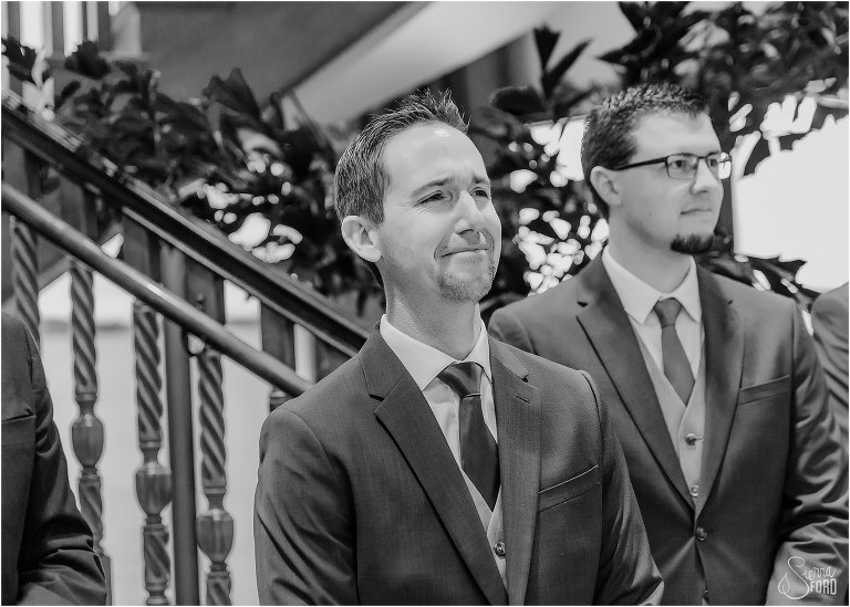 groom becomes emotional seeing his bride come down aisle at waterfront wedding ceremony