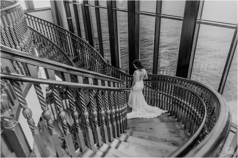 bride descends grand staircase at Tavares Pavilion before waterfront wedding