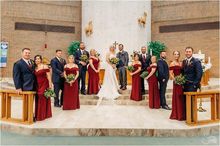 bride & groom surrounded by wedding party in burgundy and navy at Horsepower Ranch wedding
