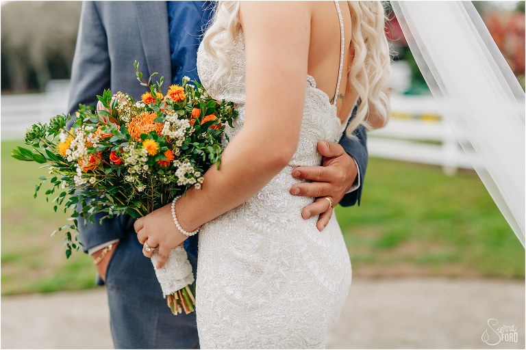 groom's hand on bride's lower back at Horsepower Ranch wedding