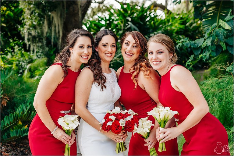 bride laughs with bridesmaids in burgundy Azazie dresses before waterfront wedding