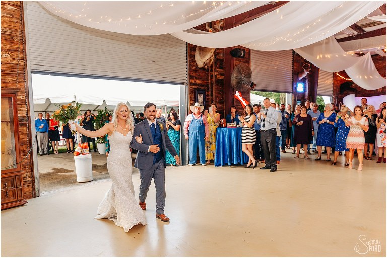 friends and family cheer as bride & groom are announced in at Horsepower Ranch wedding reception