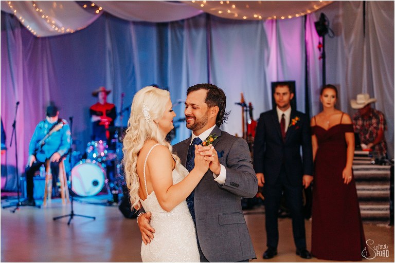 groom smiles at bride as they share first dance as husband and wife at Horsepower Ranch wedding