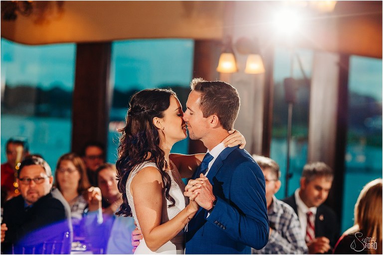 bride & groom share kiss during first dance at waterfront wedding reception