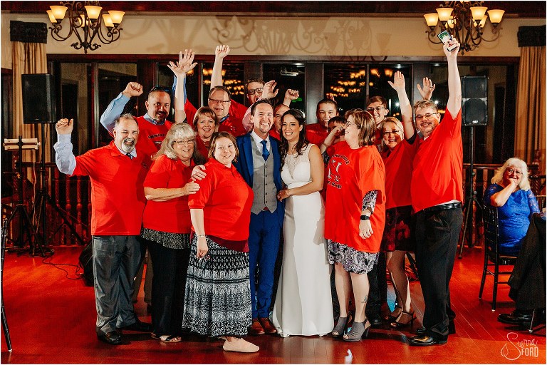 bride & groom pose with guests in matching tshirts at waterfront wedding reception