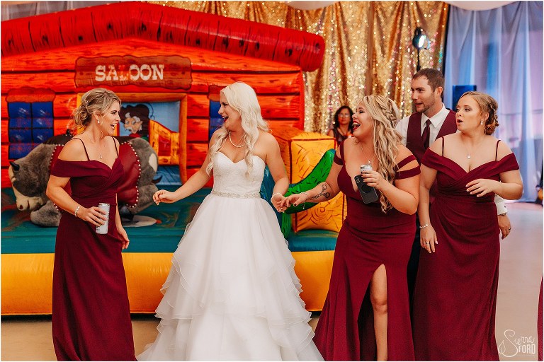 bride laughs with her bridesmaids at Horsepower Ranch wedding reception