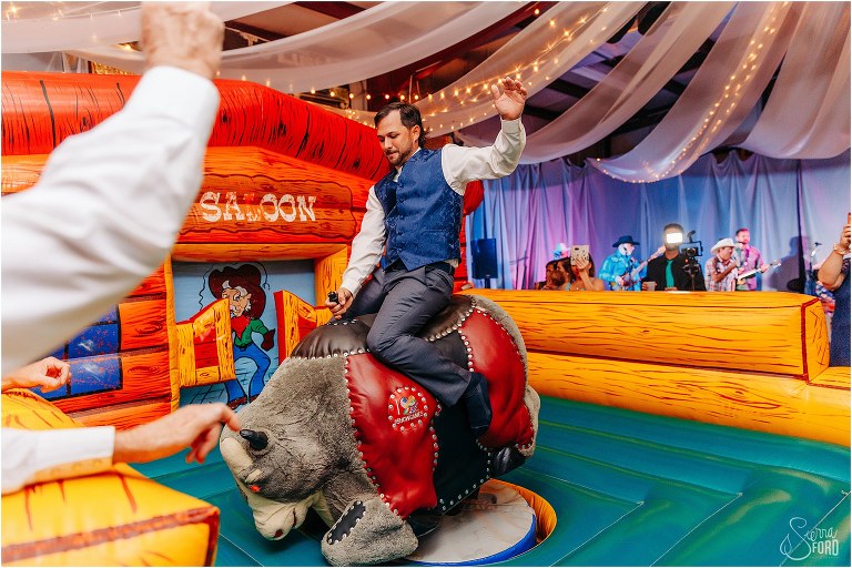 groom shows off skills at riding mechanical bull at Horsepower Ranch wedding