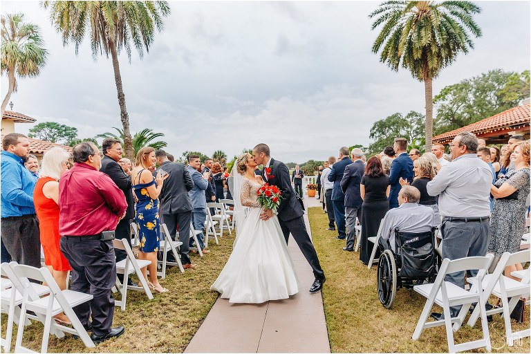 groom kisses his new wife as friends and family cheer at Mission Inn Resort wedding ceremony