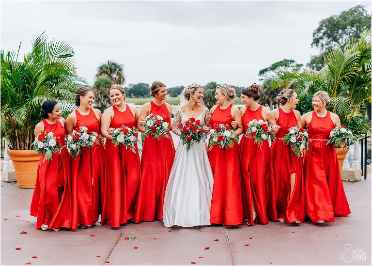 bride laughs with her bridesmaids in red David's Bridal bridesmaid dresses at Mission Inn Resort wedding