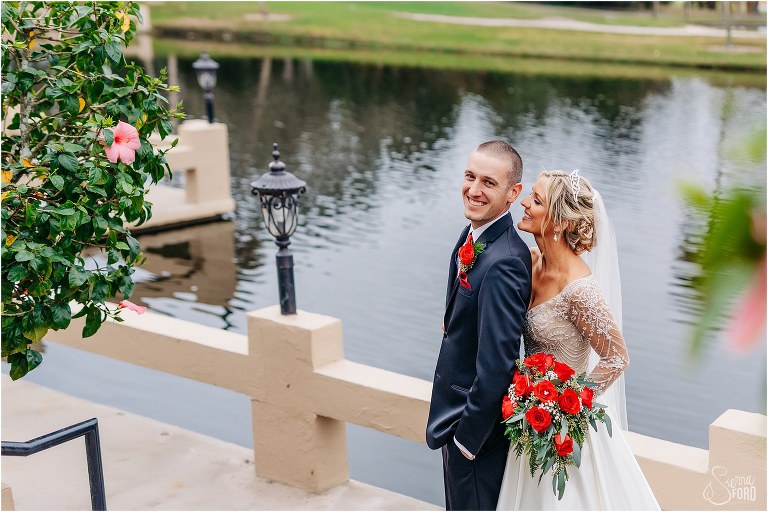 a peak through the greenery as bride whispers in groom's ear at Mission Inn Resort wedding