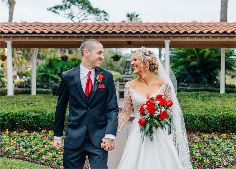 bride & groom laugh as they stroll hand in hand through courtyard at Mission Inn Resort wedding