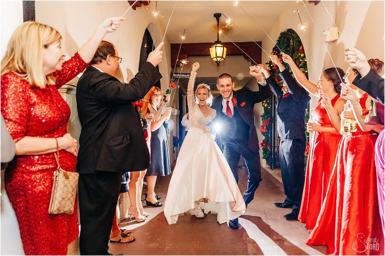 bride & groom sheer as they run through sparkler tunnel at Mission Inn Resort wedding reception